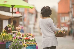 Person mit Korb an einem Marktstand